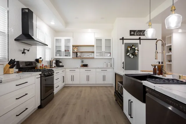 a kitchen with stainless steel appliances granite countertop a stove a sink and a refrigerator