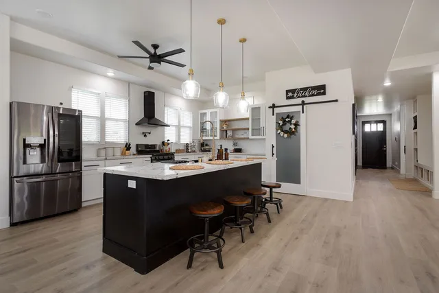 a kitchen with a refrigerator a sink dishwasher a stove and a refrigerator with wooden floor