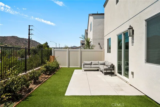 a view of a chair and tables in the back yard of the house