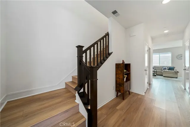 a view of a hallway with wooden floor and staircase