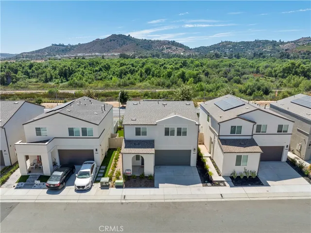 an aerial view of a house with a garden and lake view