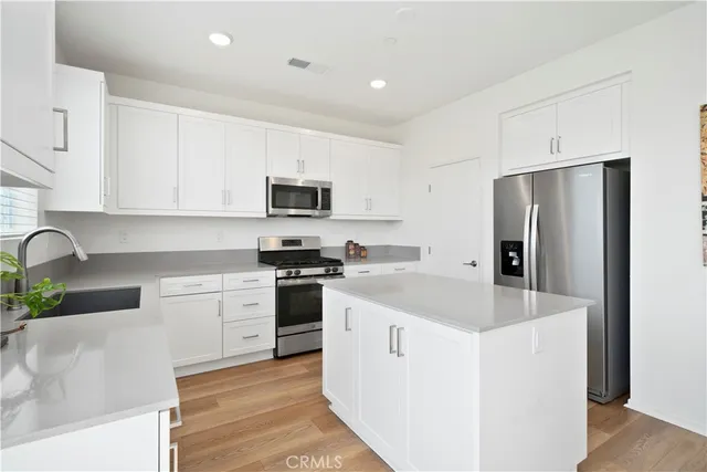 a kitchen with stainless steel appliances granite countertop a refrigerator sink and stove