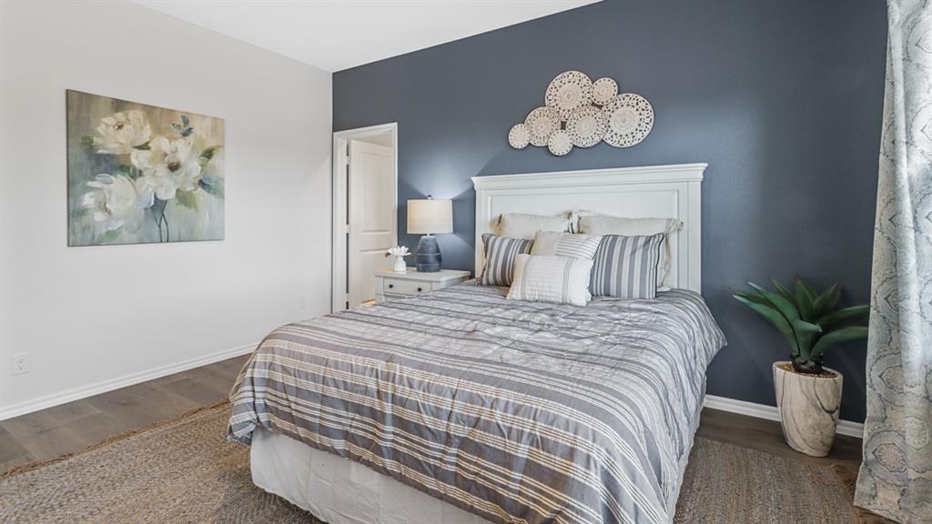 1667 Mantle Road Crandall, TX 75114 - Photo 15 of 20 Bedroom featuring a paneled headboard, wood-finish flooring, and white baseboards