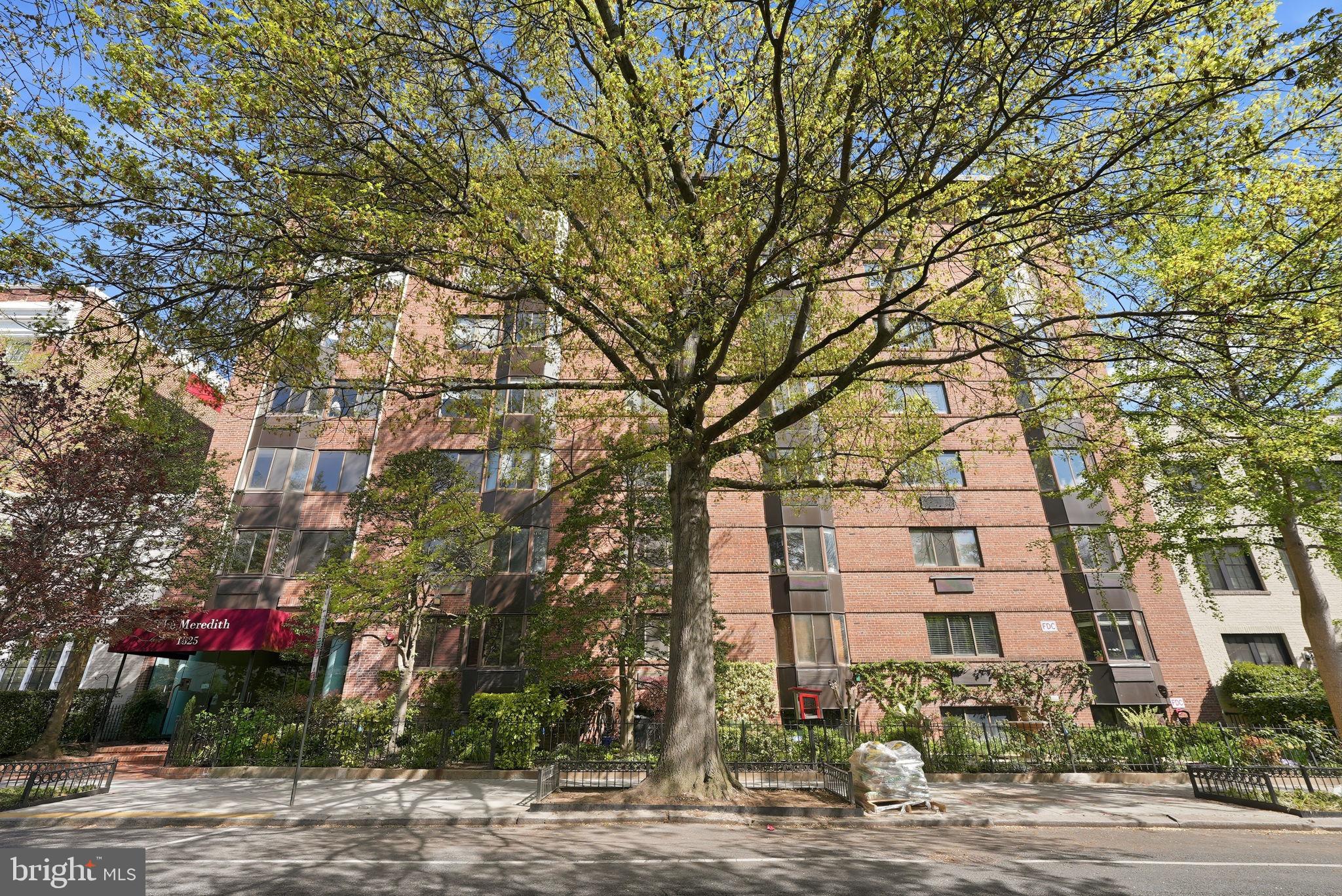 1825 T Street Northwest, Unit 207 Washington, DC 20009 - Photo 21 of 22 a view of a brick building next to a road with large trees
