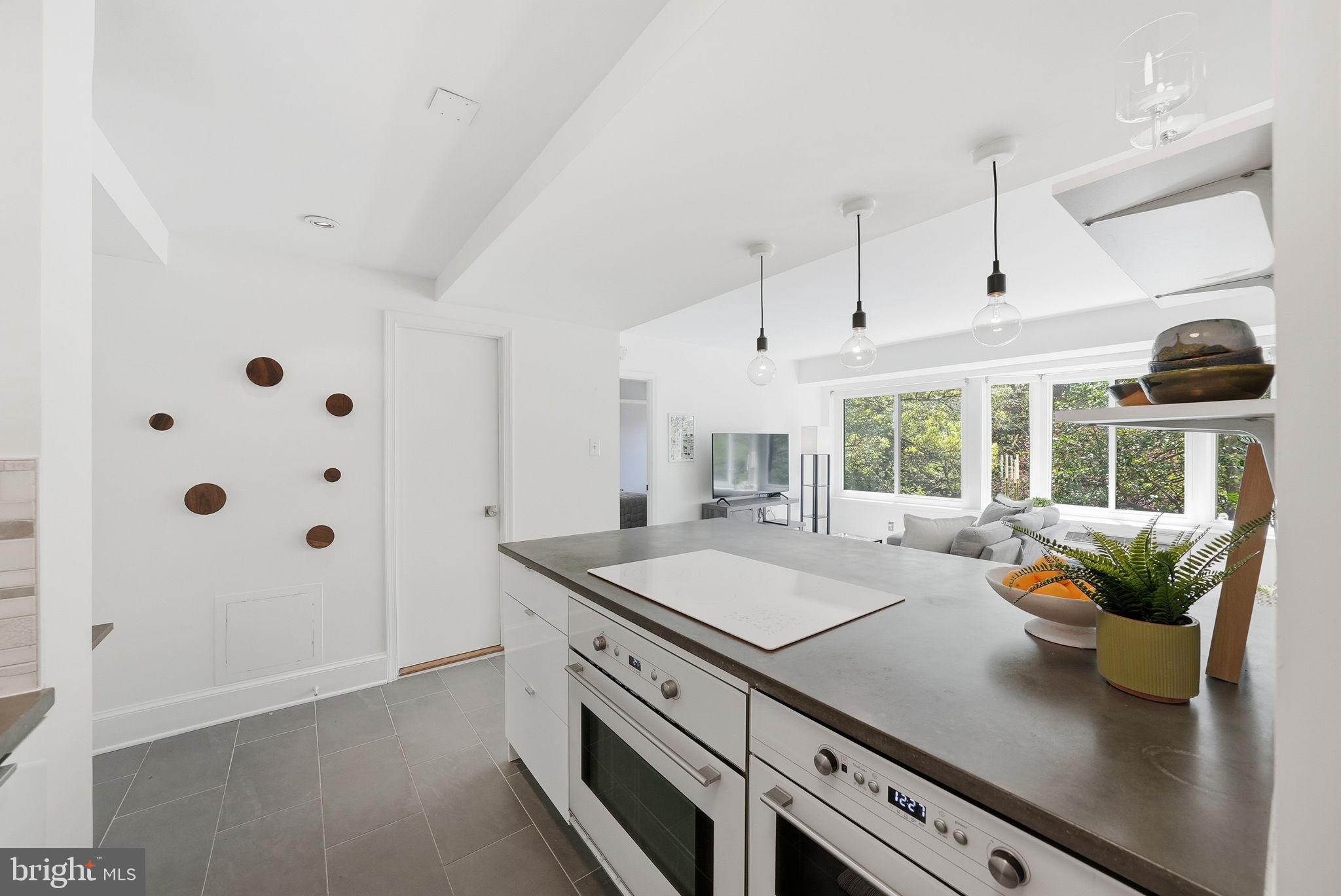 1825 T Street Northwest, Unit 207 Washington, DC 20009 - Photo 9 of 22 a kitchen with stainless steel appliances granite countertop a sink a stove and a wooden floors