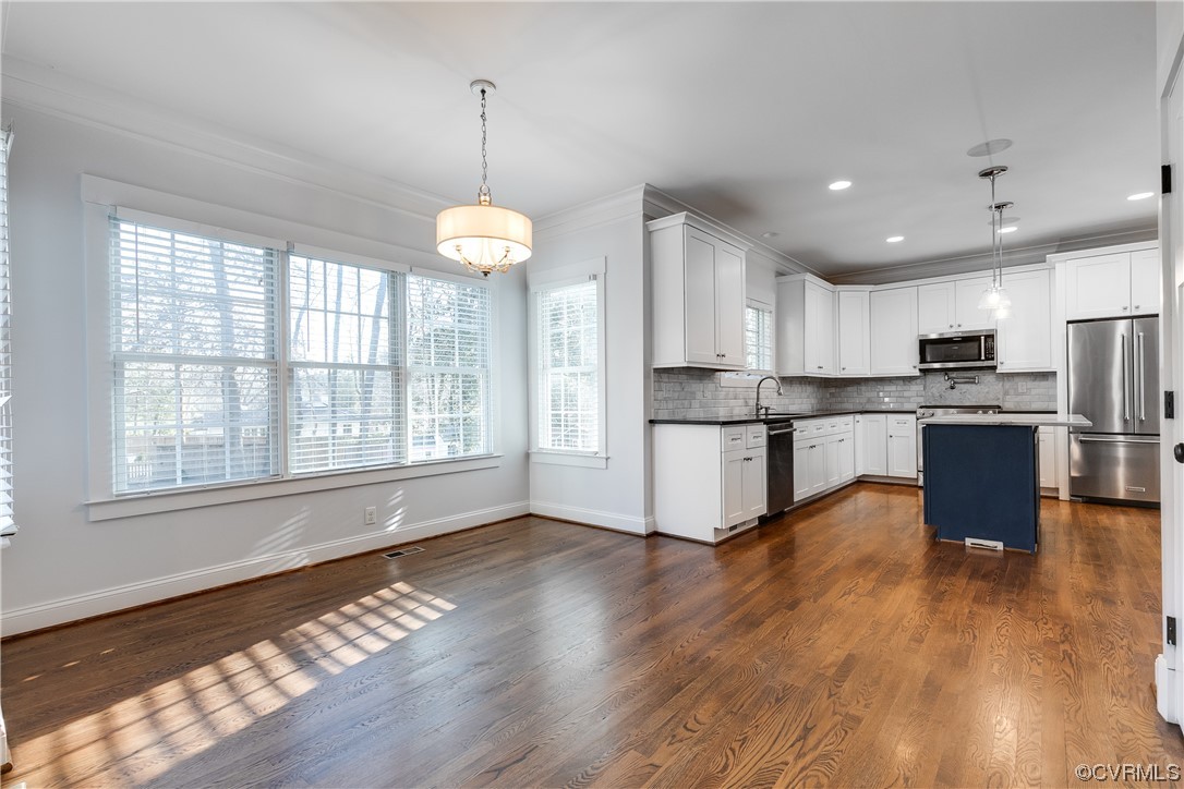 7203 Pinetree Road Henrico, VA 23229 - Photo 12 of 50 a kitchen with stainless steel appliances granite countertop a refrigerator a stove top oven a sink dishwasher and a dining table with wooden floor