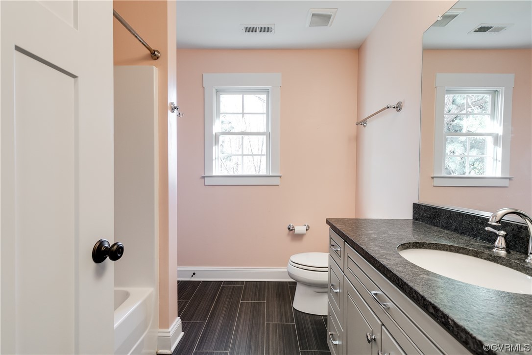 7203 Pinetree Road Henrico, VA 23229 - Photo 39 of 50 a bathroom with a granite countertop sink toilet a mirror and shower