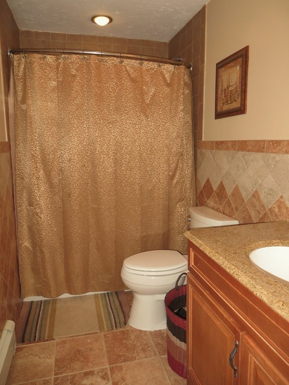 24 Raynor Road Sudbury, MA 01776 - Photo 15 of 30 a bathroom with a granite countertop toilet and a shower