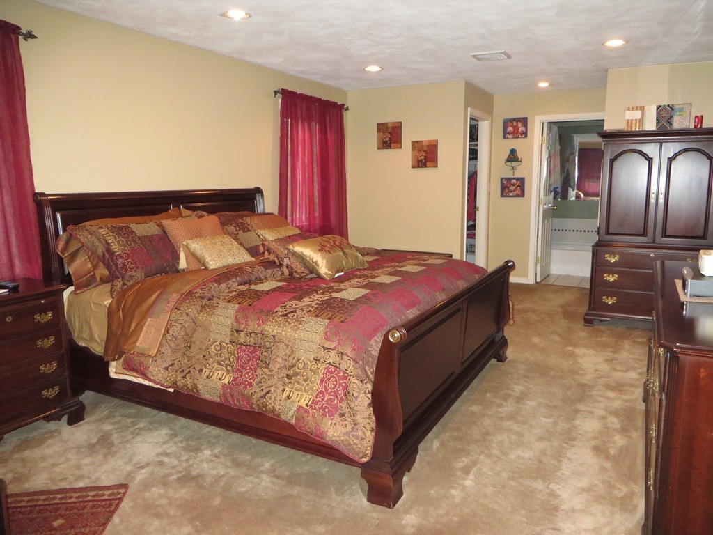 24 Raynor Road Sudbury, MA 01776 - Photo 17 of 30 a bed sitting in a room next to a lamp