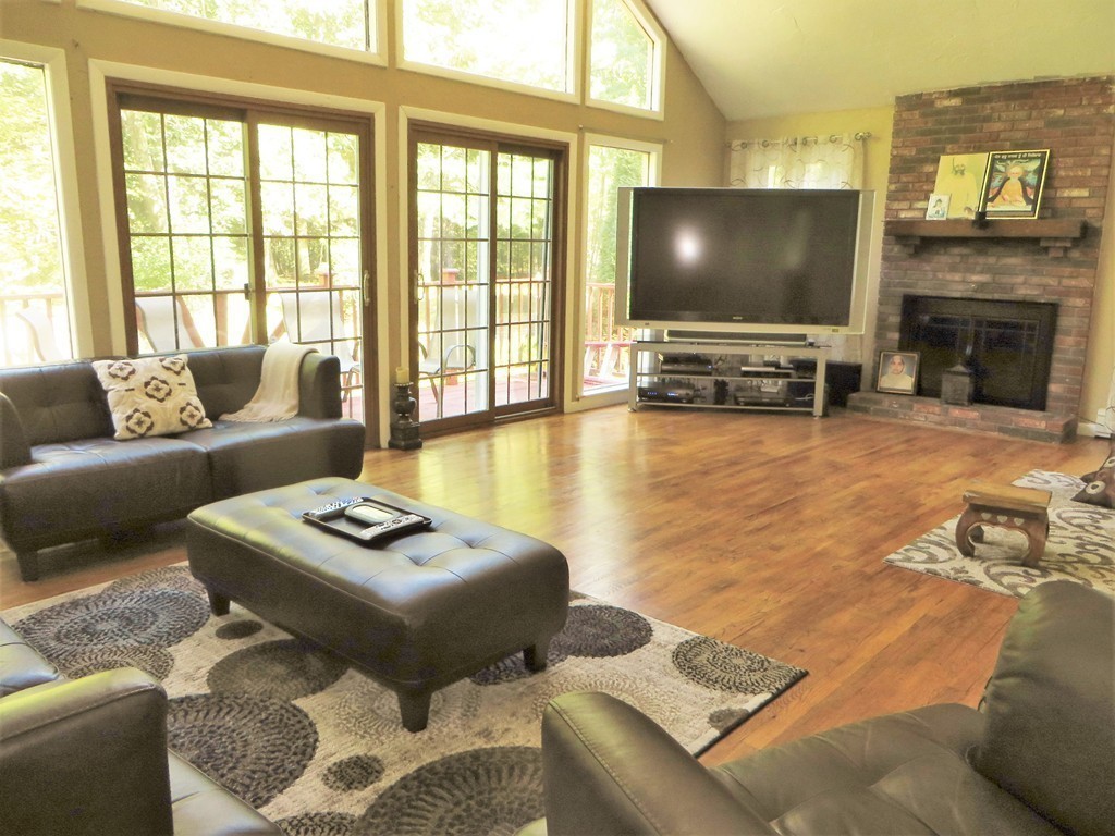 24 Raynor Road Sudbury, MA 01776 - Photo 25 of 30 a living room with furniture a flat screen tv and a floor to ceiling window