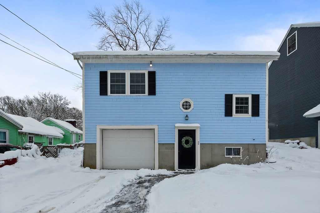 a front view of a house with yard and parking