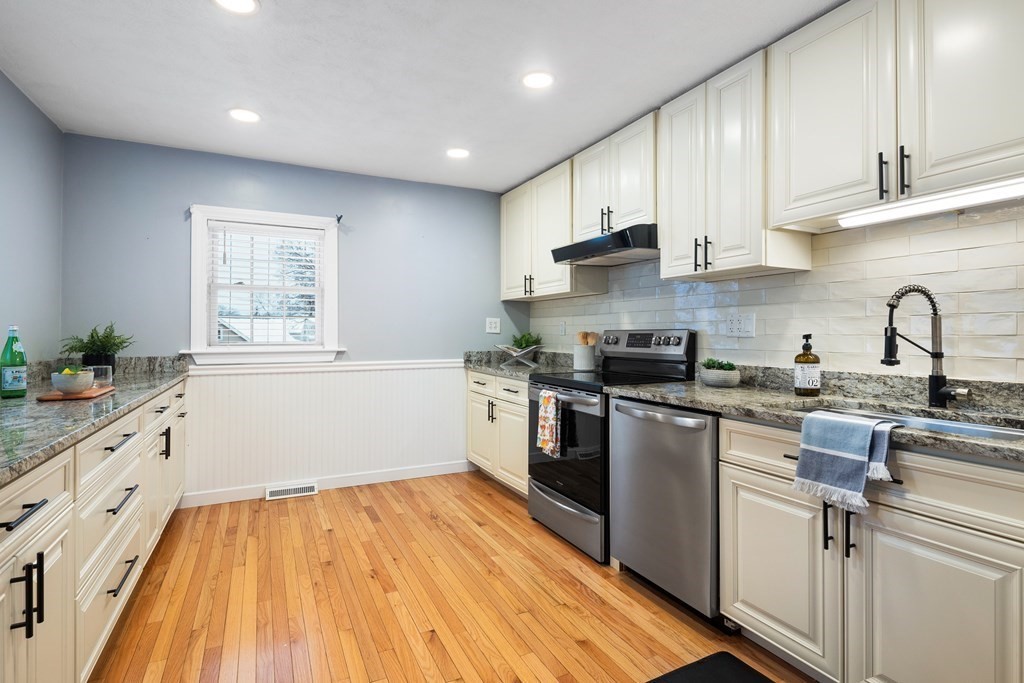 9 Fuller Road Billerica, MA 01821 - Photo 6 of 27 a kitchen with granite countertop a stove top oven a sink dishwasher and white cabinets with wooden floor