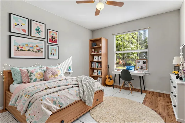 a bedroom with a bed a table and a large window