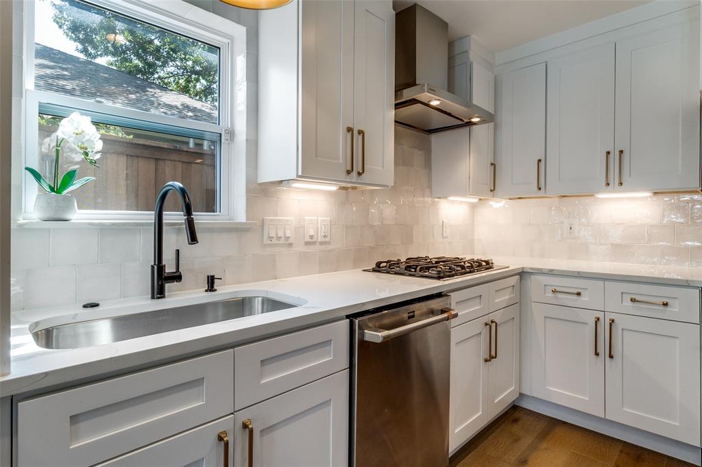 9243 Moss Farm Lane Dallas, TX 75243 - Photo 14 of 37 a kitchen with stainless steel appliances granite countertop a sink stove and cabinets