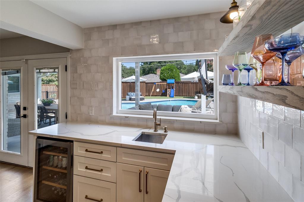 9243 Moss Farm Lane Dallas, TX 75243 - Photo 15 of 37 a hallway with view of kitchen with stainless steel appliances a sink and a large window