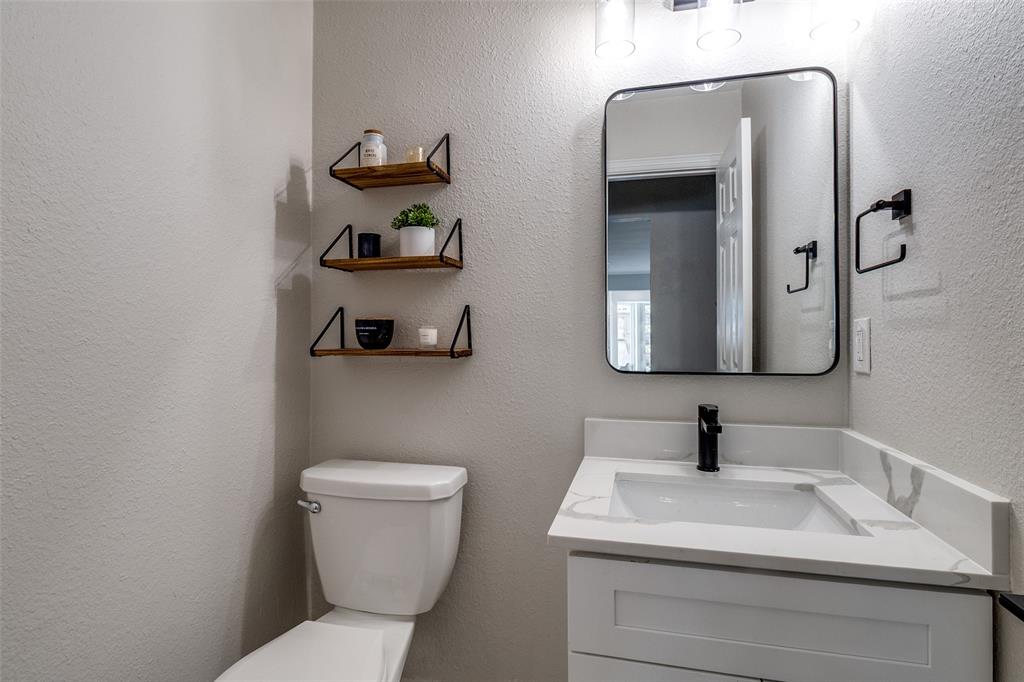 9243 Moss Farm Lane Dallas, TX 75243 - Photo 16 of 37 a bathroom with a toilet sink and mirror