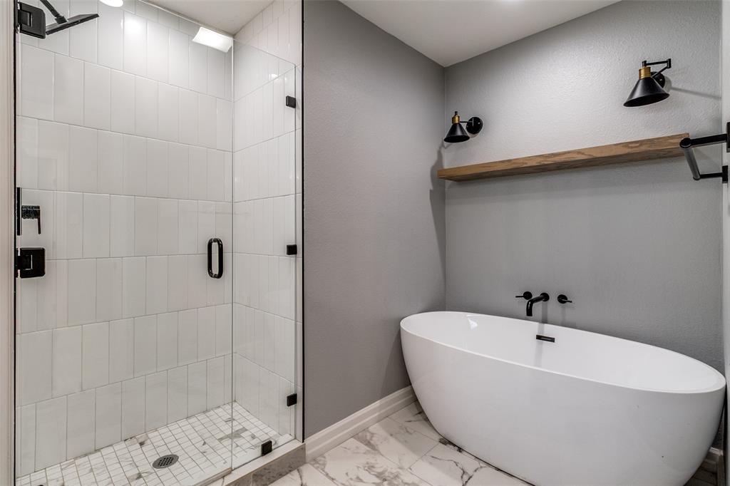9243 Moss Farm Lane Dallas, TX 75243 - Photo 21 of 37 a white bath tub sitting next to a shower