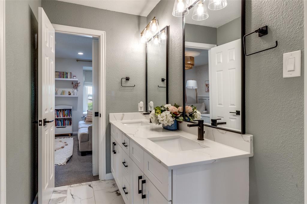 9243 Moss Farm Lane Dallas, TX 75243 - Photo 25 of 37 a bathroom with a sink double vanity and a mirror