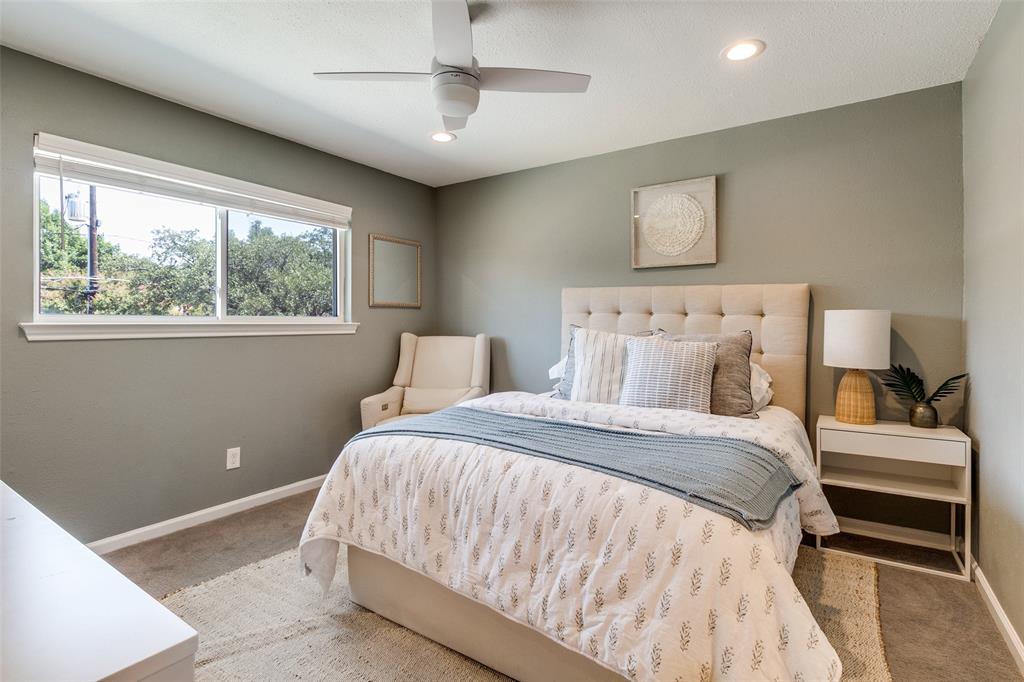 9243 Moss Farm Lane Dallas, TX 75243 - Photo 27 of 37 a bedroom with a large bed and a chandelier