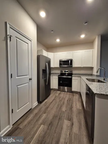 a large kitchen with a refrigerator a stove top oven a sink and dishwasher