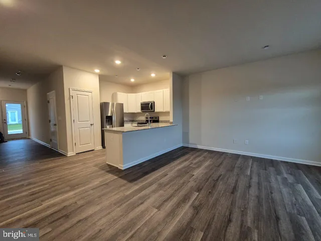 a kitchen with stainless steel appliances kitchen island wooden floors and granite counter tops