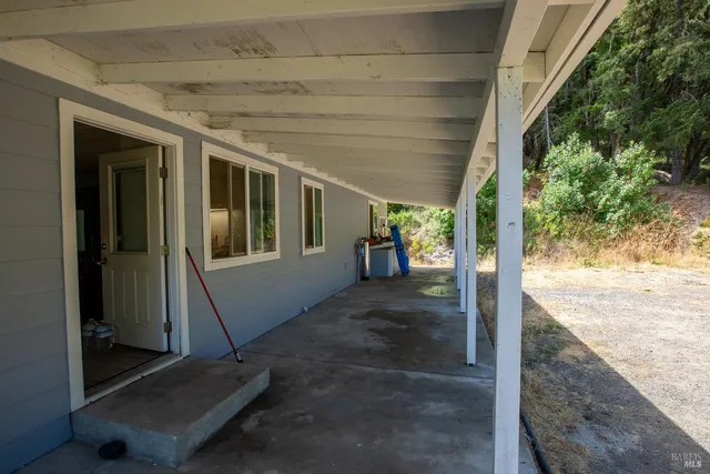 a view of a porch with furniture and a yard