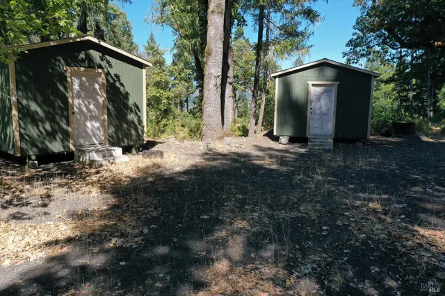 a view of a house with backyard and trees