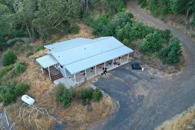 an aerial view of a house with a yard basket ball court and outdoor seating