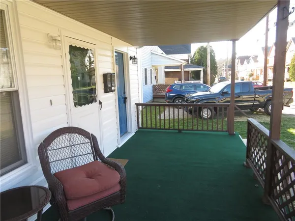 a view of a porch with furniture and a yard