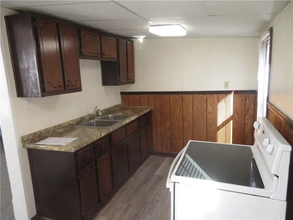 a kitchen with a sink a refrigerator and cabinets