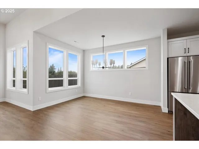a view of a kitchen with wooden floor electronic appliances and window