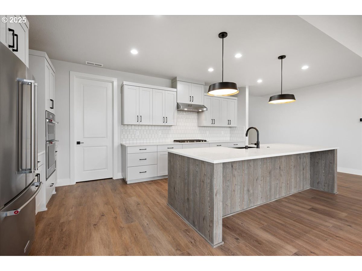 3517 North 11th Circle Ridgefield, WA 98642 - Photo 14 of 44 a kitchen with kitchen island a sink stainless steel appliances and cabinets