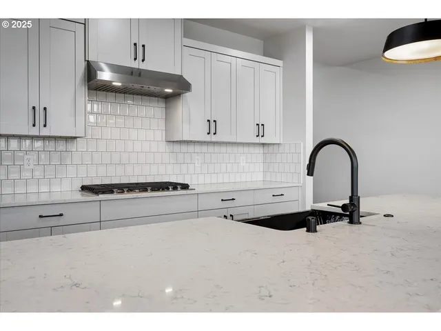 a kitchen with a sink a stove and cabinets