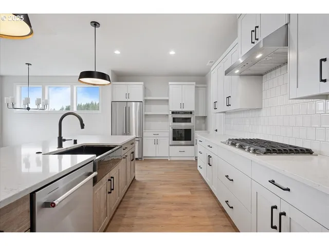 a kitchen with stainless steel appliances granite countertop a sink stove and cabinets