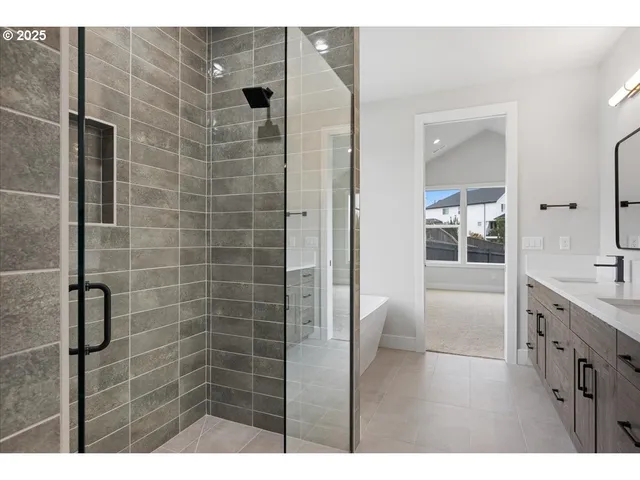 a bathroom with a granite countertop sink a large mirror and a shower