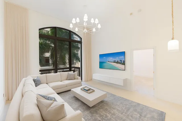 a bedroom with a bed and a large mirror next to a window