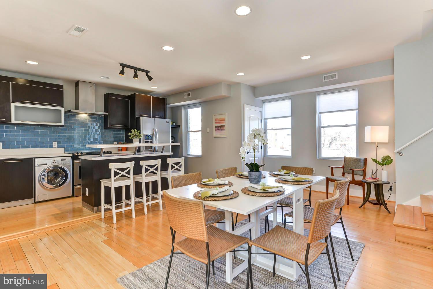 a dining room with stainless steel appliances kitchen island granite countertop a table and chairs