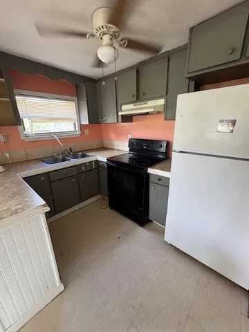 a kitchen with stainless steel appliances granite countertop a sink and a refrigerator