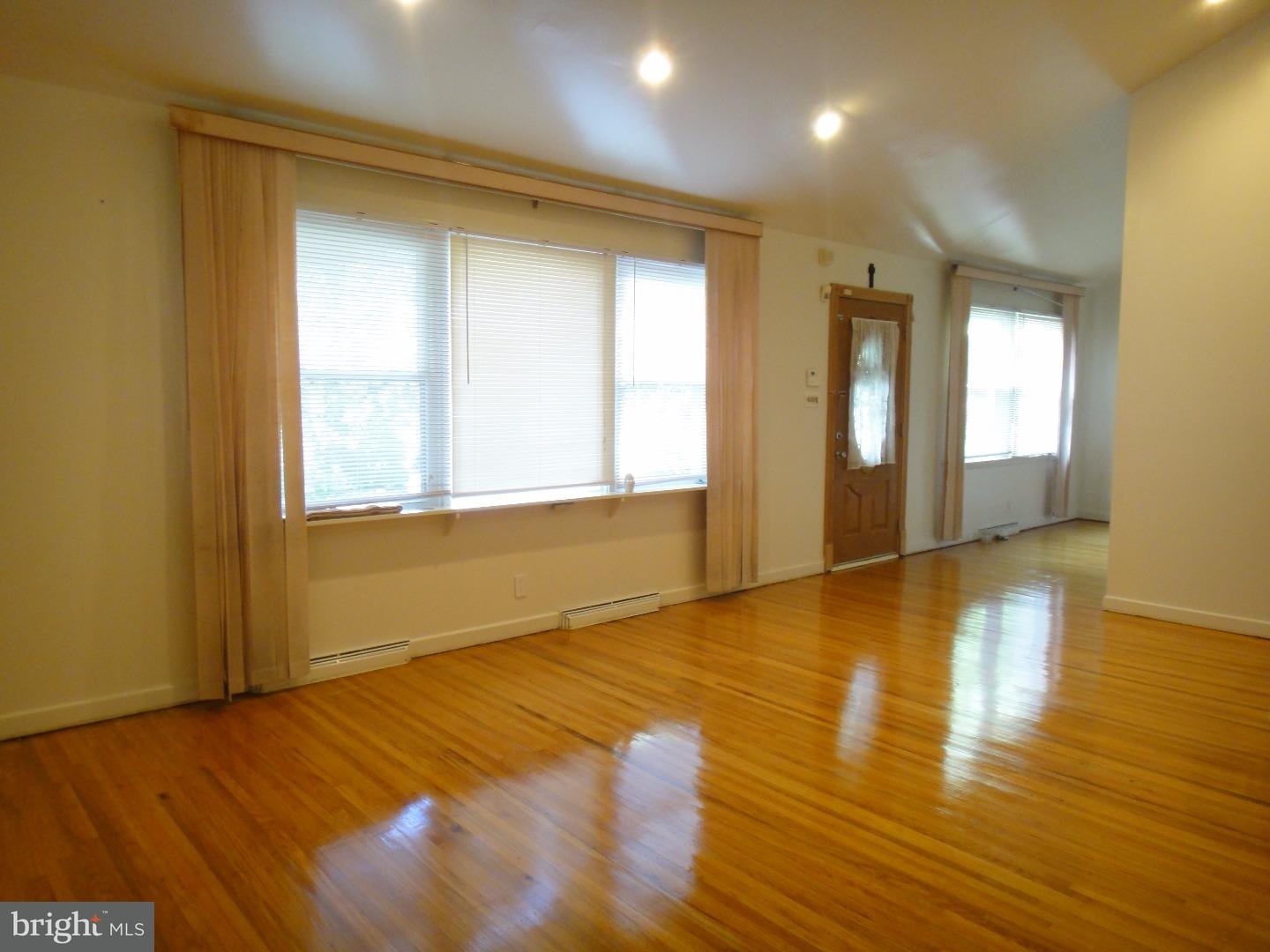 823 Suffolk Road Jenkintown, PA 19046 - Photo 3 of 19 a view of an empty room with wooden floor and a window