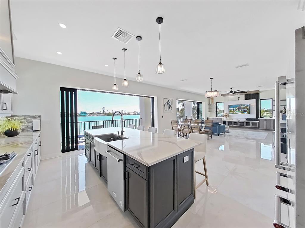 882 Bay Point Drive Madeira Beach, FL 33708 - Photo 17 of 73 a large kitchen with kitchen island a sink a counter top space and stainless steel appliances