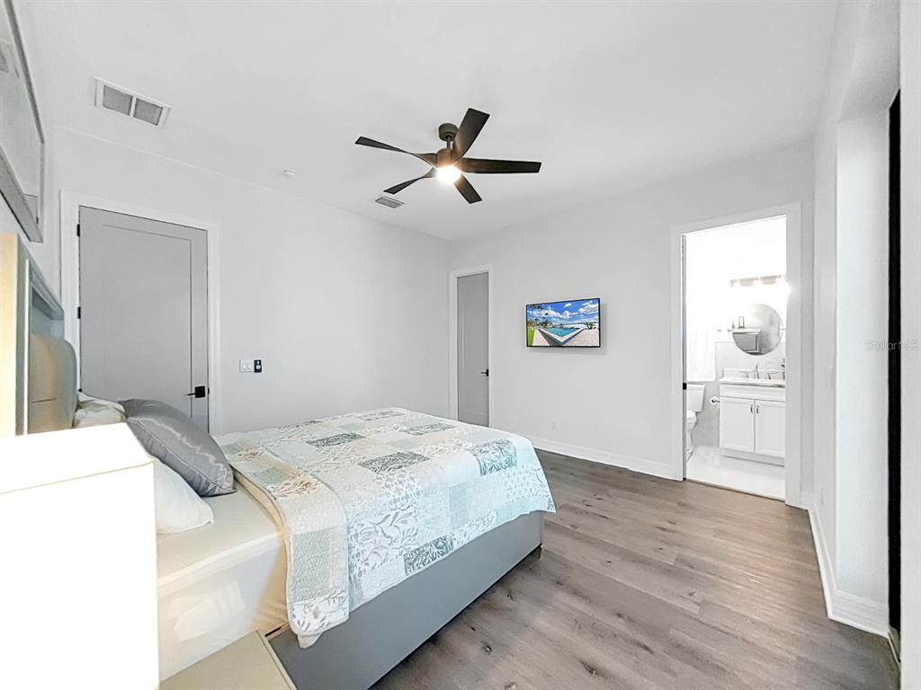 882 Bay Point Drive Madeira Beach, FL 33708 - Photo 18 of 73 a bedroom with a bed and a chandelier