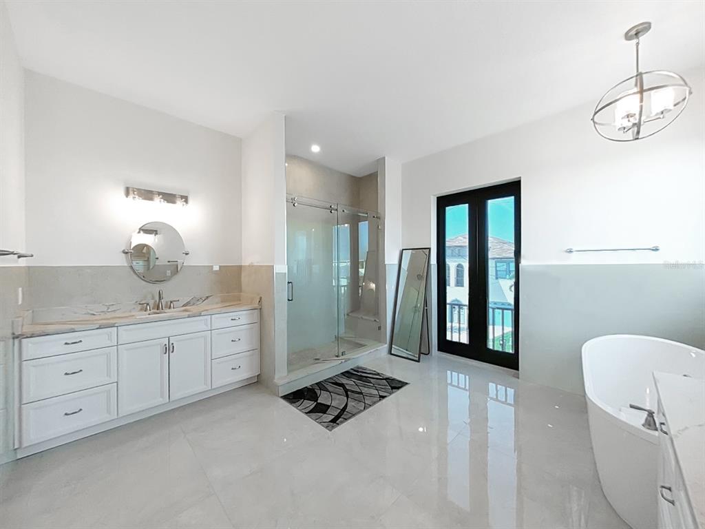 882 Bay Point Drive Madeira Beach, FL 33708 - Photo 28 of 73 a spacious bathroom with a granite countertop sink mirror and bathtub