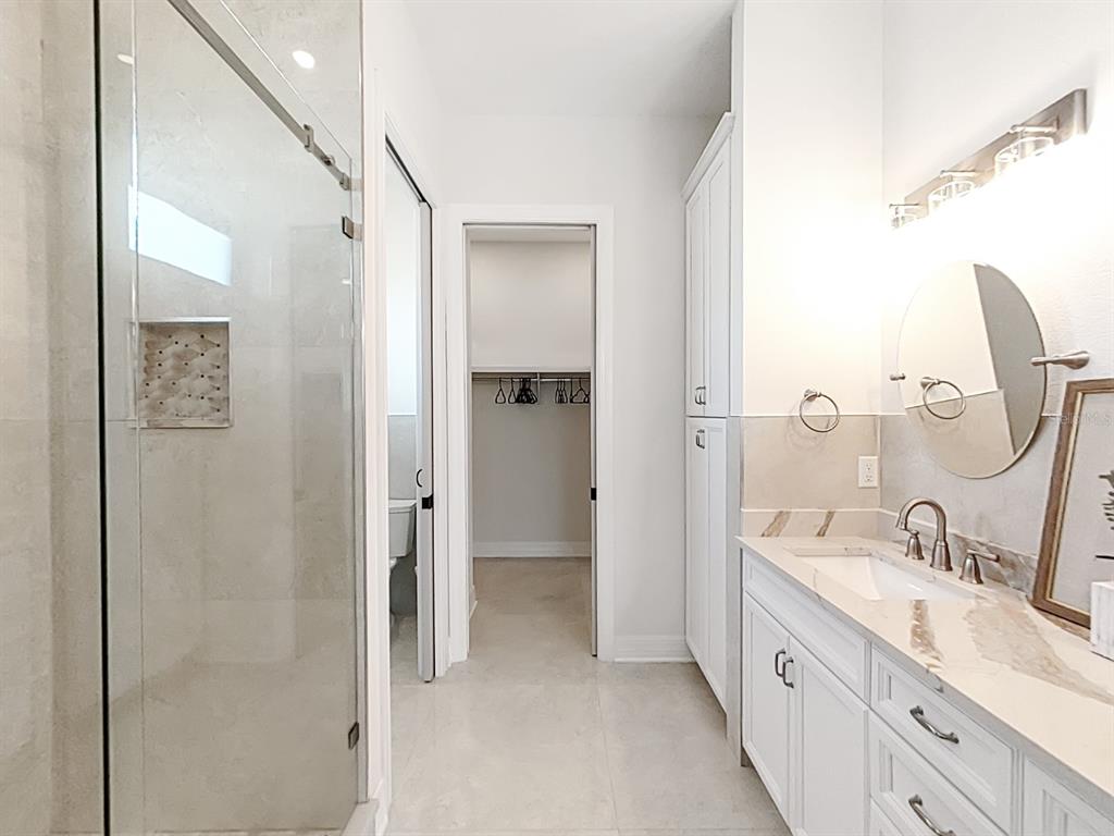 882 Bay Point Drive Madeira Beach, FL 33708 - Photo 38 of 73 a spacious bathroom with a double vanity sink mirror and shower