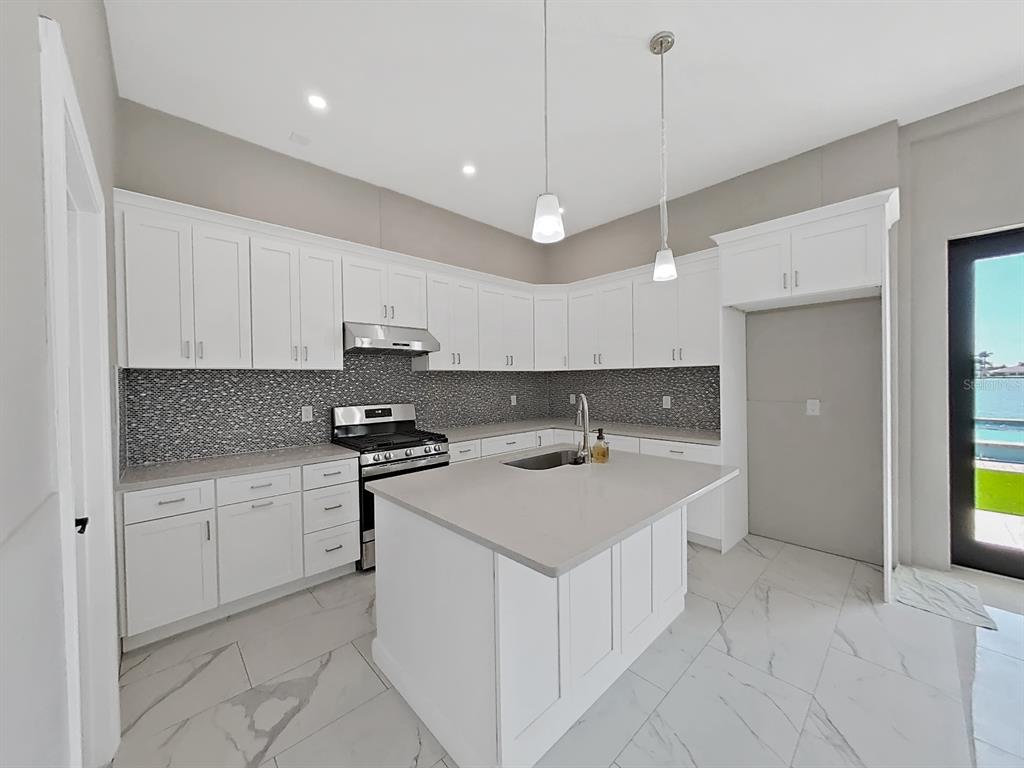 882 Bay Point Drive Madeira Beach, FL 33708 - Photo 45 of 73 a kitchen with stainless steel appliances granite countertop a sink and a refrigerator