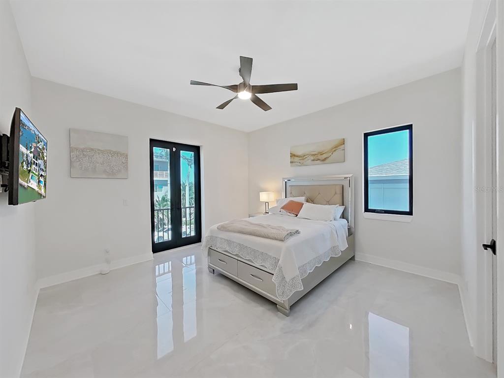 882 Bay Point Drive Madeira Beach, FL 33708 - Photo 50 of 73 a bedroom with a large bed and a chandelier fan
