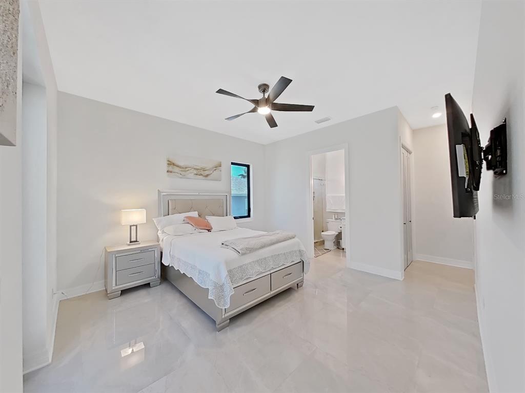 882 Bay Point Drive Madeira Beach, FL 33708 - Photo 51 of 73 a room with a bed and a ceiling fan