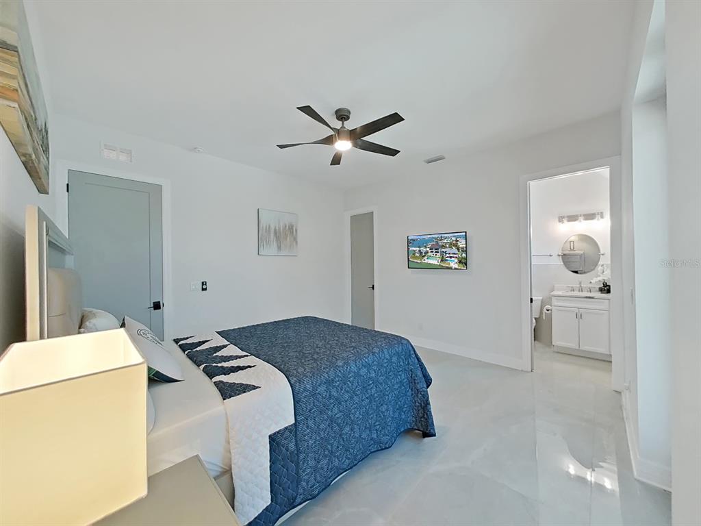 882 Bay Point Drive Madeira Beach, FL 33708 - Photo 54 of 73 a bedroom with a bed and a chandelier