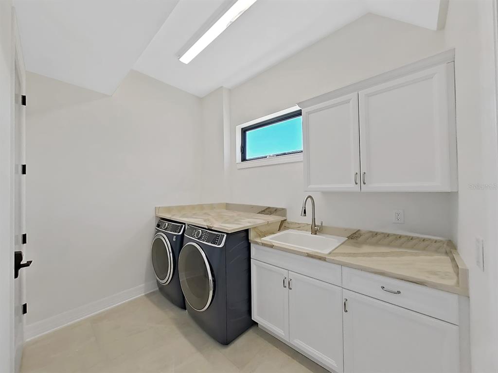 882 Bay Point Drive Madeira Beach, FL 33708 - Photo 57 of 73 a utility room with sink dryer and washer