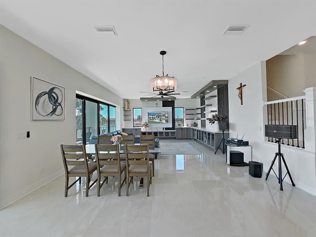 882 Bay Point Drive Madeira Beach, FL 33708 - Photo 10 of 73 a dining room with furniture a chandelier and wooden floor