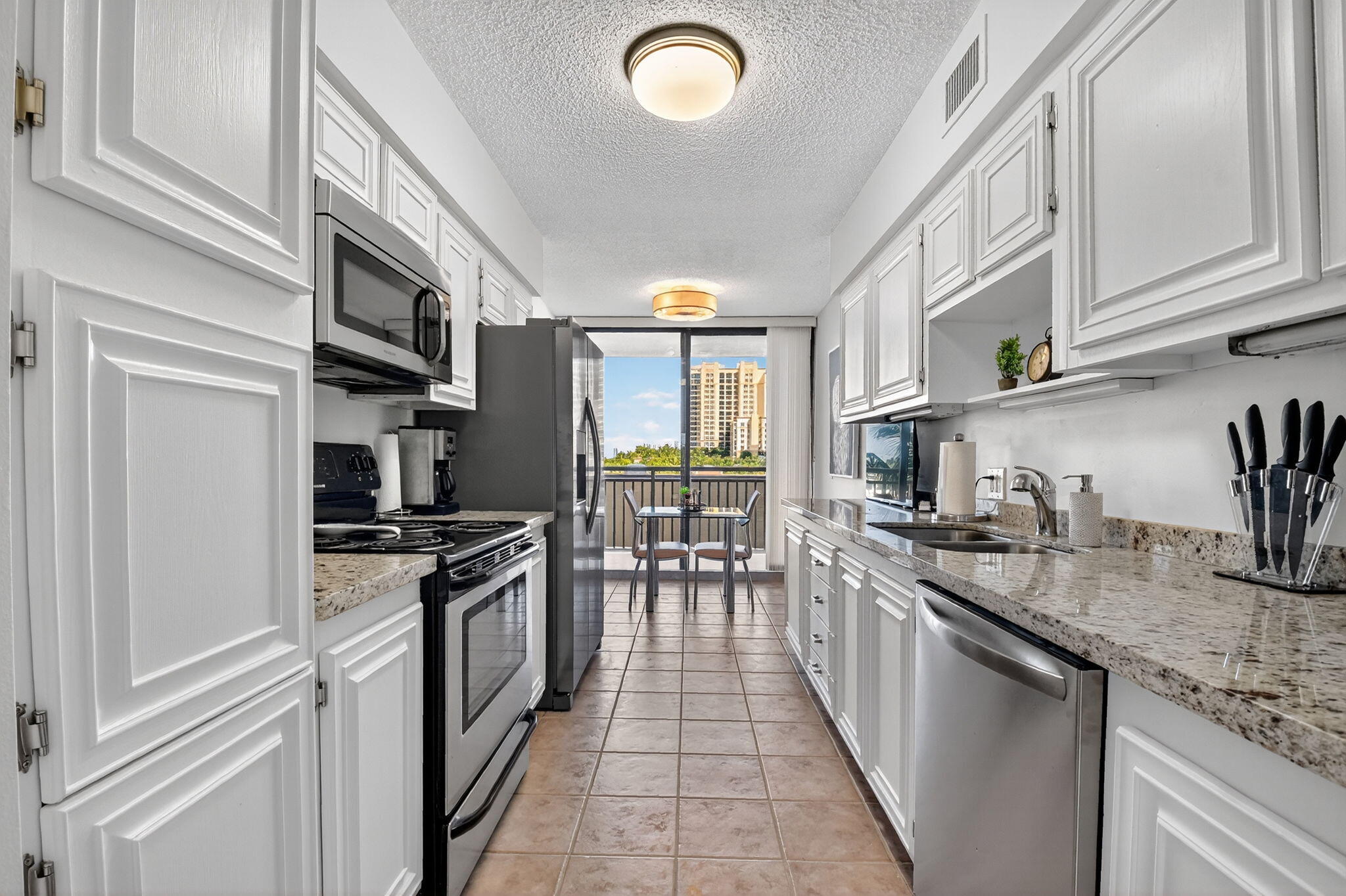 3400 North Ocean Drive, Unit 405 Riviera Beach, FL 33404 - Photo 11 of 58 a kitchen with stainless steel appliances granite countertop a stove and a sink